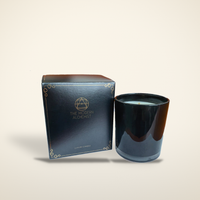 The Firelight Hour soy candle in its gift box beside the black glass vessel, on a warm candlelight cream background
