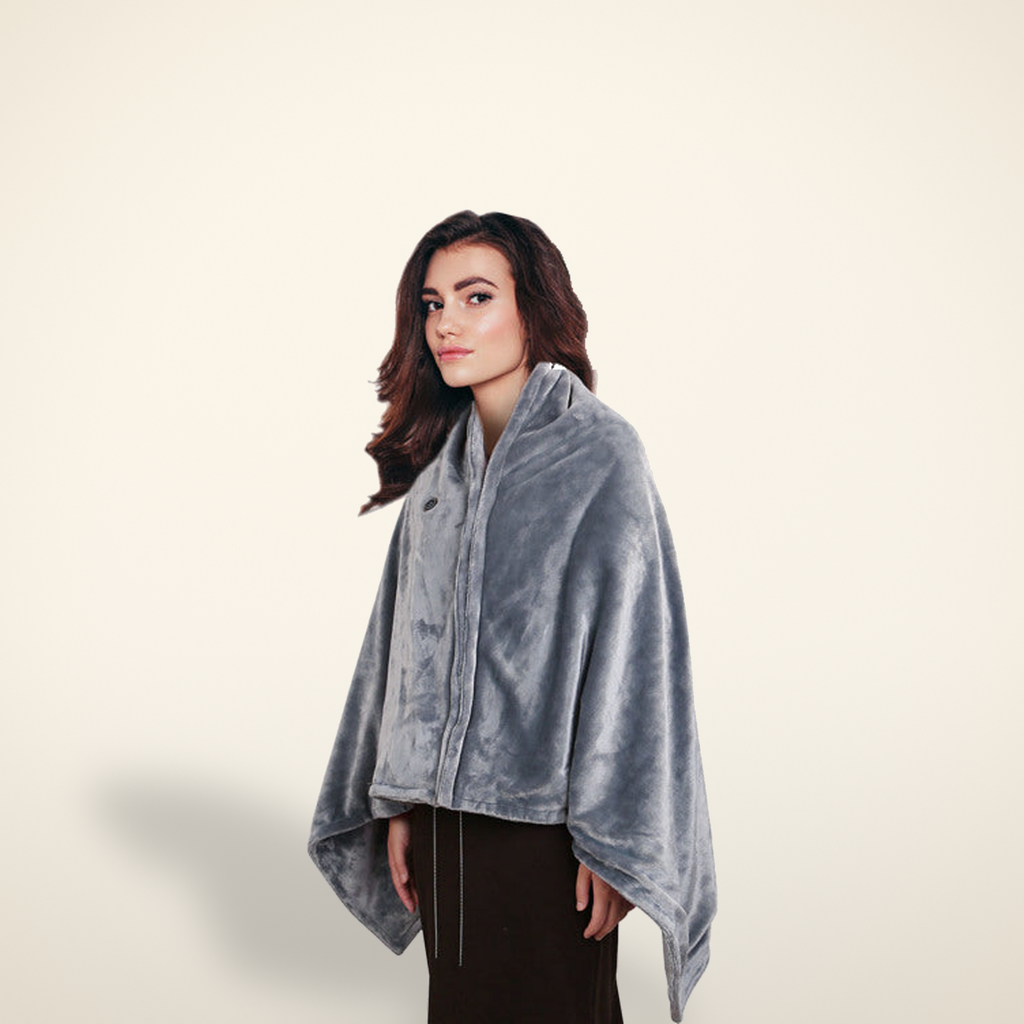 Heated plush shawl in grey, shown wrapped, on a warm candlelight cream background